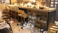 Peralatan makan berserakan di tanah di sebuah restoran setelah gempa bumi, di Fukushima, Jepang (17/3/2022). Gempa kuat Magnitudo 7,3 mengguncang lepas pantai Fukushima di Jepang utara pada hari Rabu (16/3), memicu peringatan tsunami. (AFP/STR/Jiji Press)