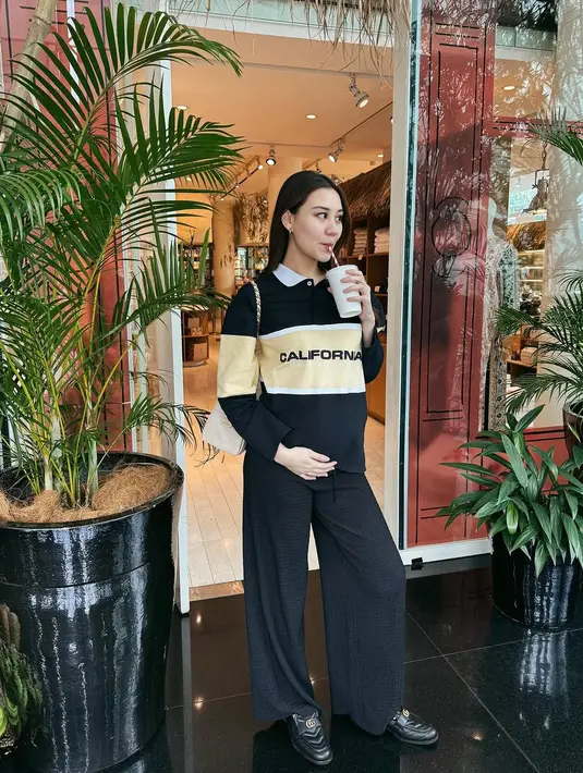 Pamer OOTD di depan pintu, Aaliyah Massaid mengenakan long sleeve stripe polo shirt dan loose pants [@aaliyah.massaid]