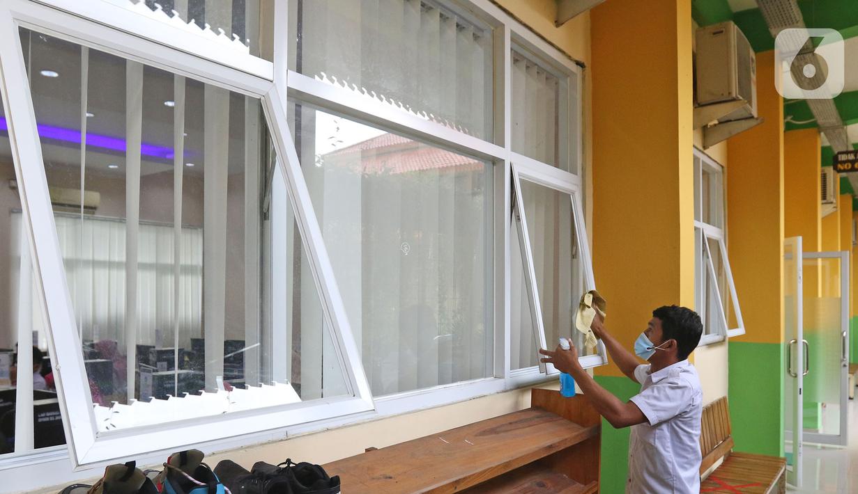 Petugas sedang membersihkan jendela di SMKN 51, Jakarta, Rabu (7/4/2021). SMKN 51 melakukan uji coba masuk sekolah dan Uji Sertifikasi Kompetensi (USK) dengan protokol kesehatan yang ketat. (Liputan6.com/Herman Zakharia)