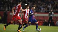 Bintang Barcelona, Lionel Messi, berusaha melewati bek Girona, Juanpe Ramirez, pada laga La Liga Spanyol di Stadion Montilivi, Girona, Sabtu (23/9/2017). Girona kalah 0-3 dari Barcelona. (AFP/Josep Lago)