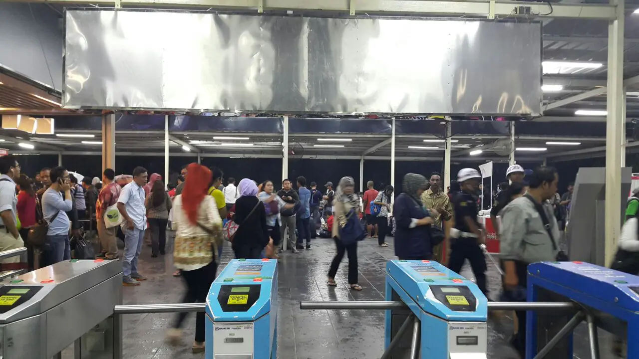 Ilustrasi calon pengguna jasa kereta api dan gerbang otomatis Kartu Multi Trip (KMT)