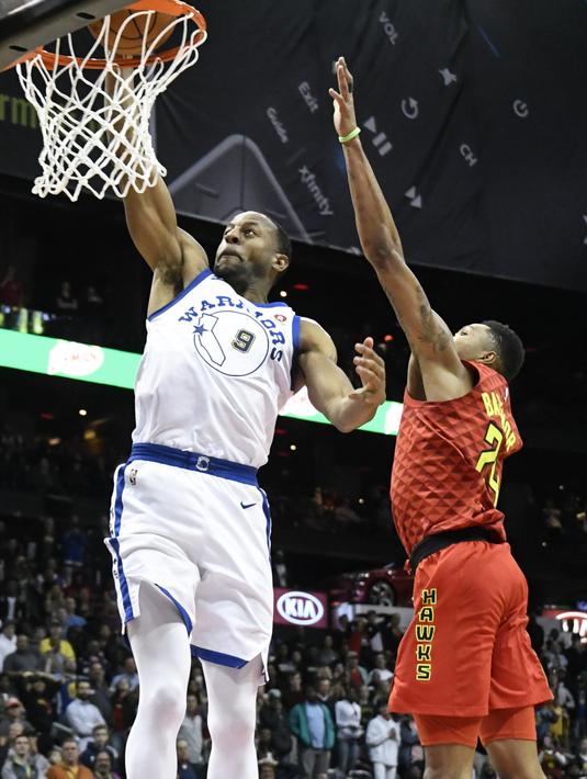 Pemain Warriors, Andre Iguodala #9 melakukan dunk saat diadang pemain Atlanta Hawks, Kent Bazemore pada laga NBA basketball game  di Philips Arena, Atlanta, (2/3/2018). Warriors menang 114-109. (AP/John Amis)