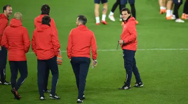 Pelatih Sevilla Vincenzo Montella (kanan) dan asistennya melihat para pemainnya latihan di stadion Old Trafford di Manchester, Inggris (12/3). Sevilla akan melawan Manchester United pada leg kedua babak 16 besar Liga Champions. (AFP Photo/Oli Scarff)