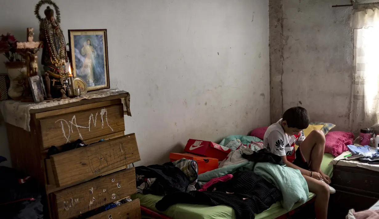 Daniel Dorado dari Argentina bersiap meninggalkan rumahnya di daerah kumuh Costa Eperanza, di Buenos Aires pada 19 September 2020. Karena pandemi, Daniel (12) yang bercita-cita menjadi pesepak bola di klub River Plate kini berlatih di rumah dengan instruksi dari pelatihnya. (ARIEL TIMY TORRES/AFP)