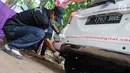 Petugas mengetes gas buang pada kegiatan uji emisi kendaraan di Taman Kota 1 BSD, Tangerang Selatan, Rabu (3/10). Dinas Lingkungan Hidup (DLH) Kota Tangerang Selatan menggelar uji emisi guna menekan angka polusi kendaraan. (Merdeka.com/Arie Basuki)