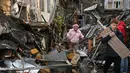 Warga setempat berjalan di halaman sebuah lingkungan perumahan yang rusak parah setelah serangan Rusia di Odesa, Ukraina, Jumat 24 April 2026. Gelombang serangan udara Rusia yang menggunakan kombinasi pesawat nirawak (drone) dan rudal kembali menghantam jantung permukiman warga Ukraina. (AP Photo/Michael Shtekel)