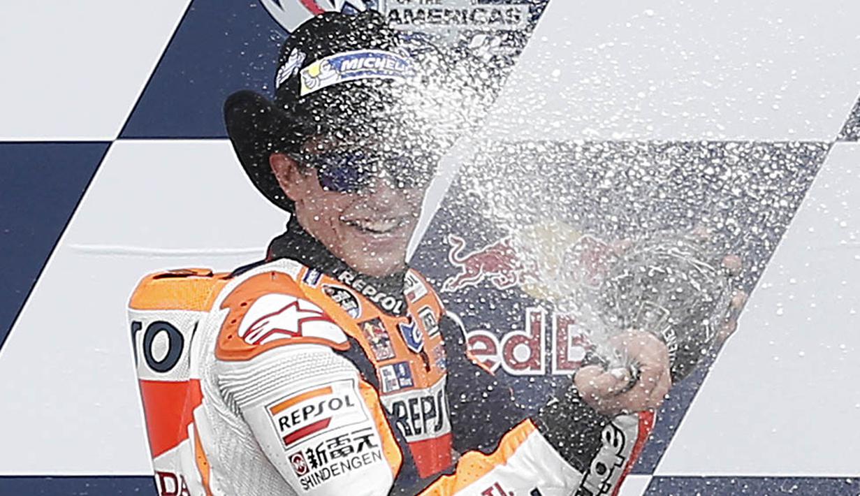 Pebalap Repsol Honda, Marc Marquez, merayakan keberhasilannya juara MotoGP Austin di Texas, Amerika Serikat, Senin (11/4/2016) dini hari WIB. Pebalap Spanyol ini juga masih memimpin klasemen sementara MotoGP. (AFP/Thomas B. Shea)