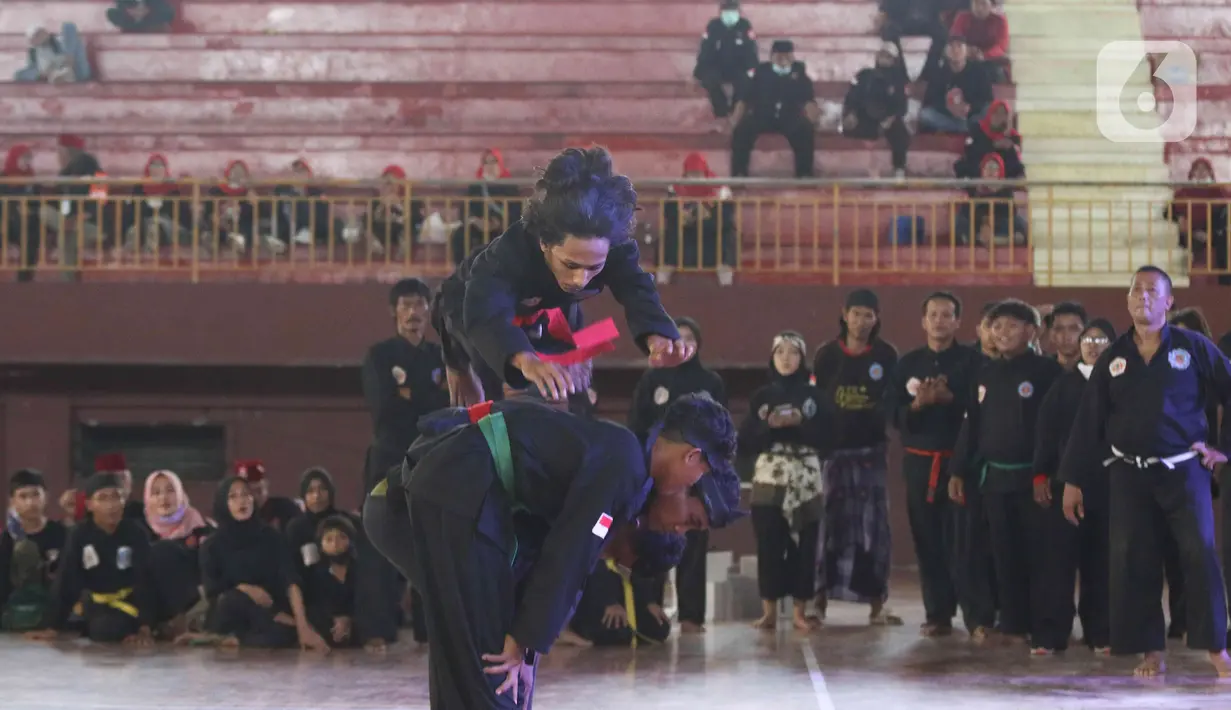 Pesilat melakukan aksi pencak silat saat pentas di Gor Ciracas, Jakarta, Selasa (22/3/2022). Dinas Kebudayaan DKI bersama sejumlah Komunitas Budaya menggelar pergelaran seni budaya untuk memperkenalkan kebudayaan pencak silat serta mengangkat kembali tradisi budaya. (Liputan6.com/Herman Zakharia)