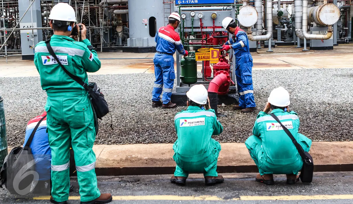 Jurnalis foto berseragam warna hijau mengabadikan kawasan kilang pengolahan minyak Pertamina (RU V) di Balikpapan, Kalimantan, Kamis (14/5). Di kawasan tersebut mereka tidak diperbolehkan membawa ponsel. (Liputan6.com/Fery Pradolo)