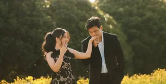 Frans dan Indah tampak memilih konsep nature pada foto prewedding mereka. Keduanya kompak mengenakan pakaian hitam, Frans mengenakan setelan jas hitam senada dengan celananya. [@fransfaisal_]
