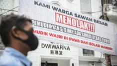 Seorang pria melintas di dekat spanduk peringatan untuk pemudik di kawasan Kartini, Sawah Besar, Jakarta, Senin (17/5/2021). Spanduk tersebut untuk memperingati warga yang kembali dari mudik lebaran agar membawa surat bebas COVID-19. (Liputan6.com/Faizal Fanani)