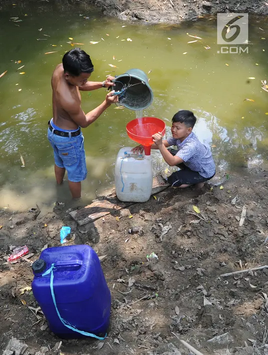 Dua anak Kampung Gamblok mengambil sisa air Kali Cihoe, Desa Ridomanah, Bekasi, Jawa Barat, Kamis (15/8/2019). Bantuan air bersih dirasa kurang bagi warga sebab distribusi tidak merata dan dilakukan hanya pada awal-awal pemberitaan media massa. (merdeka.com/Arie Basuki)