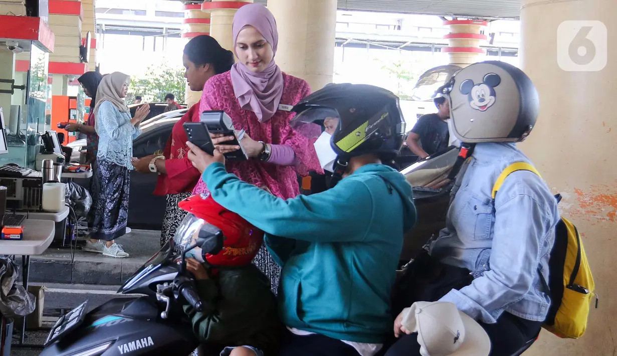 Petugas melayani pengunjung saat tiba di gerbang pintu Ancol Jakarta, Minggu (21/4/2024). (Liputan6.com/Herman Zakharia)