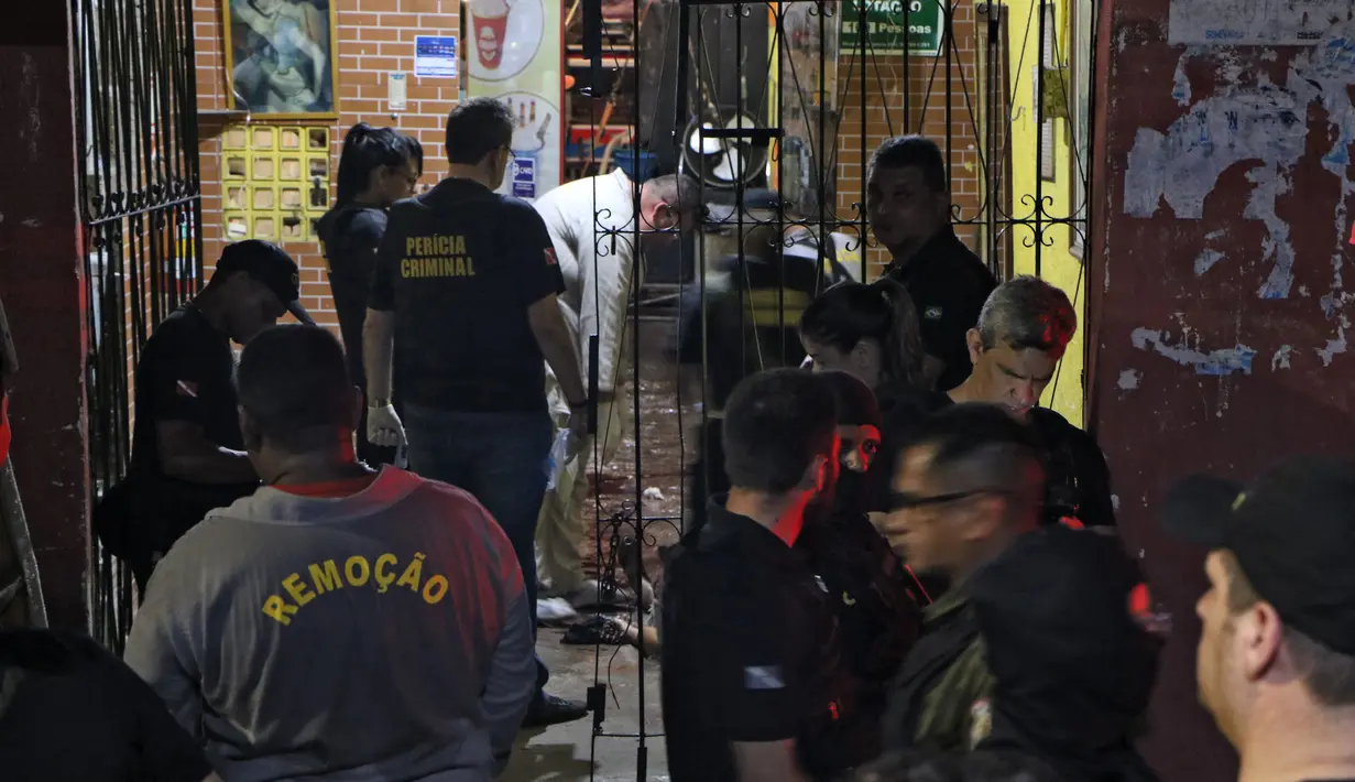 Sejumlah petugas saat mengevakuasi korban penembakan massal di sebuah bar di kota Belm, negara bagian utara Par, Brazil (19/5/2019). Sebanyak 11 orang dilaporkan tewas dalam serangan yang dilakukan 7 pria bersenjata tersebut. (Claudio Pinheiro/Agencia Panamazonica/AFP)