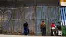 Sejumlah warga tampak menunggu untuk bertemu keluarganya di pagar perbatasan antara Meksiko dan Amerika Serikat, Playas Tijuana, Meksiko, (12/4). Tembok ini memisahkan antara Meksiko dan Amerika Serikat. (REUTERS / Jorge Duenes)