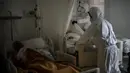 Petugas kamar jenazah mengenakan APD saat mengurus jenazah lansia yang meninggal karena COVID-19 di sebuah panti jompo, Barcelona, Spanyol, 5 November 2020. Seperti dokter dan perawat, petugas kamar jenazah adalah bagian dari sekelompok pekerja penting di tengah pandemi. (AP Photo/Emilio Morenatti)