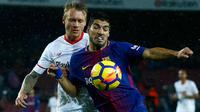 Penyerang Barcelona, Luis Suarez berusaha membawa bola dari kawalan pemain Sevilla, Simon Kjaer saat bertanding pada lanjutan La Liga Spanyol di Camp Nou, Barcelona, Spanyol, (4/11). Barcelona menang 2-1 atas Sevilla. (AP Photo/Manu Fernandez)