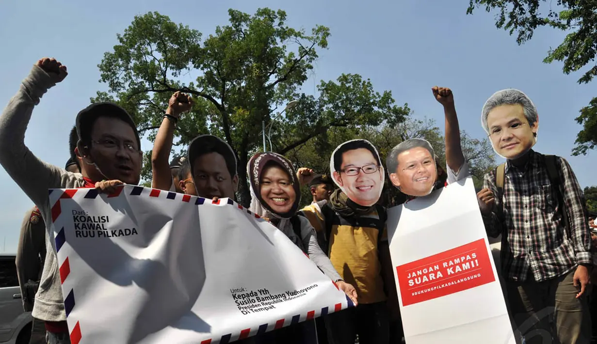 Para aktivis menggunakan topeng sejumlah kepala daerah saat melakukan aksi di depan Istana Merdeka, (16/8/14). (Liputan6.com/Miftahul Hayat)