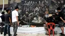 Seniman lokal menyelesaikan mural berjudul 'The Heroes' di Chiang Rai, 18 Juli 2018. Mural itu untuk menghormati upaya penyelamatan 12 remaja dan pelatih sepak bola mereka yang terperangkap di  gua selama lebih dari dua minggu. (AFP/Lillian SUWANRUMPHA)