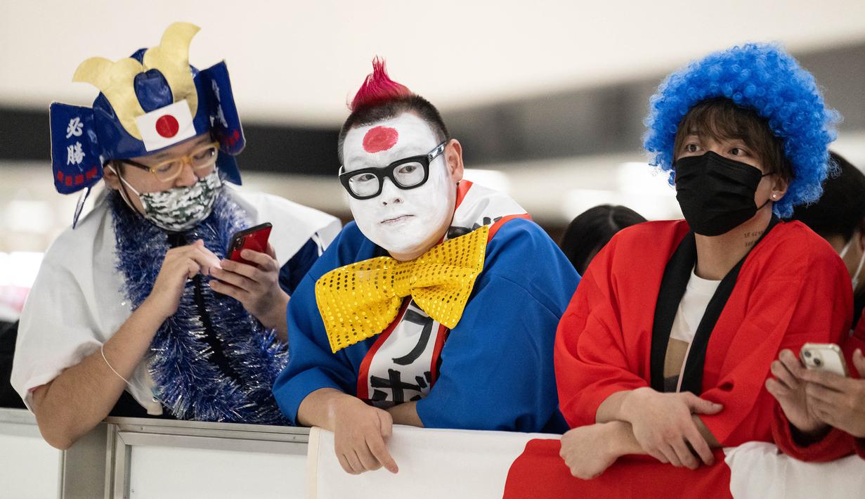 Tidak hanya di lapangan, Jepang juga disorot karena aksi mengagumkan suporter mereka selama di Piala Dunia 2022. Seperti yang banyak diketahui, para pendukung Samurai biru selalu melakukan aksi bersih-bersih dengan memungut sampah yang ada di tribun penonton setelah laga usai. (AFP/Yuichi Yamazaki)