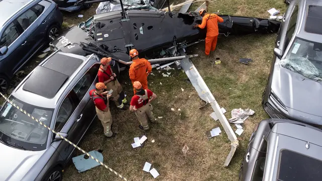 Petugas pemadam kebakaran di lokasi kecelakaan helikopter di Rio de Janeiro pada Minggu 14 Juni 2026. Penyanyi Oliver Tree termasuk satu dari enam korban. (Tercio TEIXEIRA / AFP)