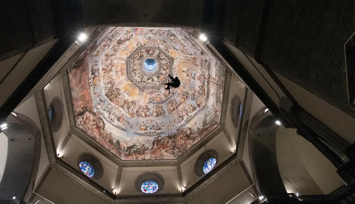 Seorang teknisi bergelantungan di tali saat ia memeriksa kubah katedral Basilica di Santa Maria del Fiore di Italia (11/1). Bangunan ini diarsiteki oleh Filippo Brunelleschi. (Claudio Giovannini/Opera del Duomo press office via AP)