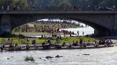 Ribuan orang menikmati cuaca musim panas di tepi sungai 'Isar' di Munich, Jerman (19/7/2020). Di tengah pandemi COVID-19, ribuan orang menikmati cuaca musim panas di dekat sungai tersebut untuk berjemur serta mendinginkan tubuh. (AP Photo/Matthias Schrader)