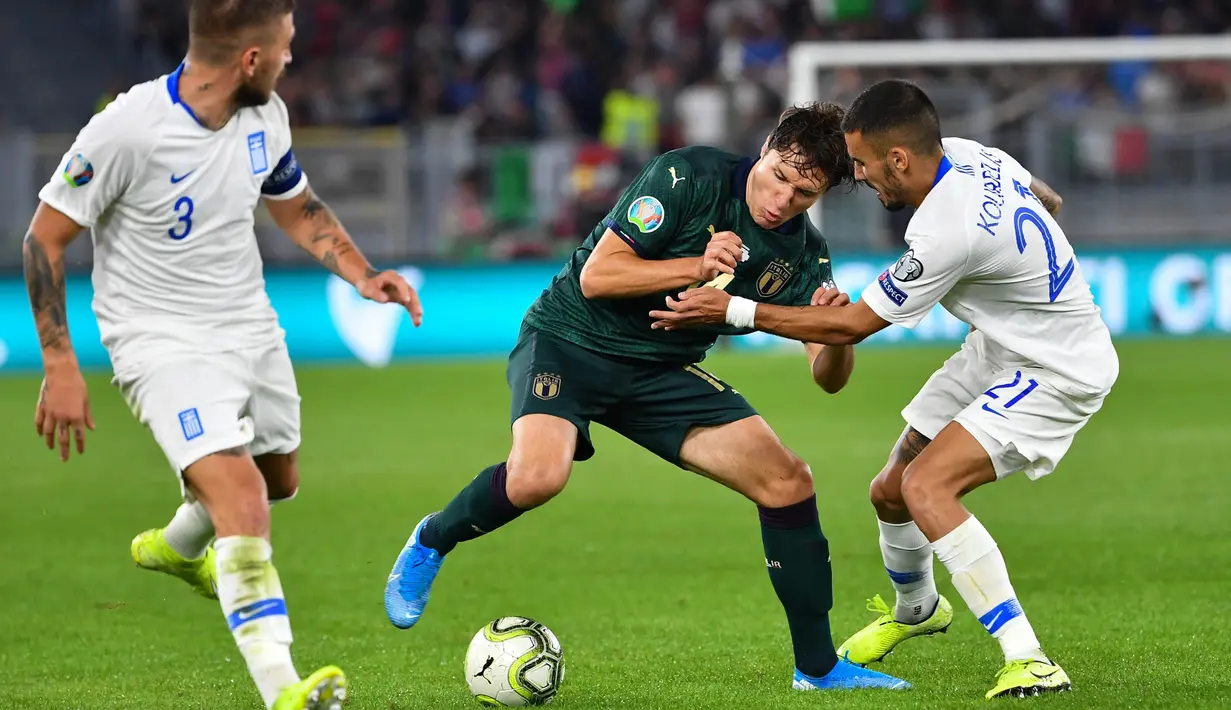 Striker Italia, Federico Chiesa, berusaha melewati bek Yunani, Kostas Stafylidis, pada laga Kualifikasi Piala Eropa 2020 di Stadion Olimpico, Roma, Sabtu (12/10). Italia menang 2-1 atas Yunani. (AFP/Alberto Pizzoli)