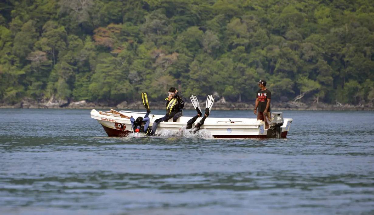 Wisatawan melompat ke air untuk menyelam scuba di lokasi penyelaman di Iboih, taman pantai dan pariwisata yang populer di seberang teluk dari Sabang di pulau Weh, provinsi Aceh (6/10/2019). Pulau Weh juga terkenal dengan ekoturismenya. (AFP Photo/Chaideer Mahyuddin)