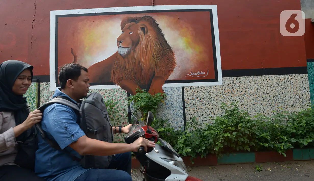 Warga melintas dekat mural yang menghiasi tembok rumah warga RT 02/RW 07 Kampung Warna-warni, Kelurahan Pengadegan, Jakarta Selatan, Selasa (10/12/2019). Mural tersebut sebagai bentuk kesadaran warga untuk menciptakan kampung yang enak dipandang, bersih, aman, dan yaman. (merdeka.com/Imam Buhori)