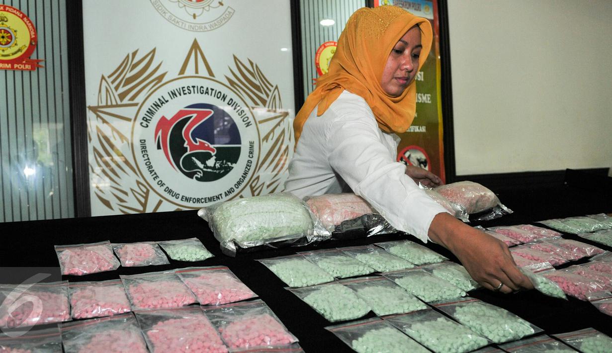 Petugas menata barang bukti narkoba saat rilis barang bukti di Mako Ditnarkoba Mabes Polri, Jakarta, Jumat (19/2). Petugas menangkap 7 orang tersangka sindikat narkotika internasional dan menyita 40 ribu butir ekstasi. (Liputan6.com/Yoppy Renato)