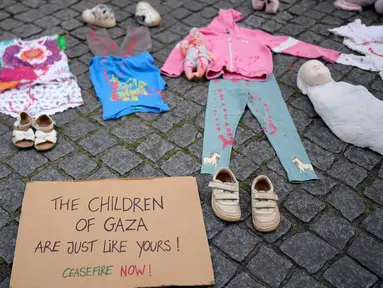 Sebuah instalasi pakaian dan mainan anak-anak tersebar di sepanjang jalan Carmo di pusat kota Lisbon, Portugal, Jumat, 30 Mei 2025. (AP Photo/Armando Franca)