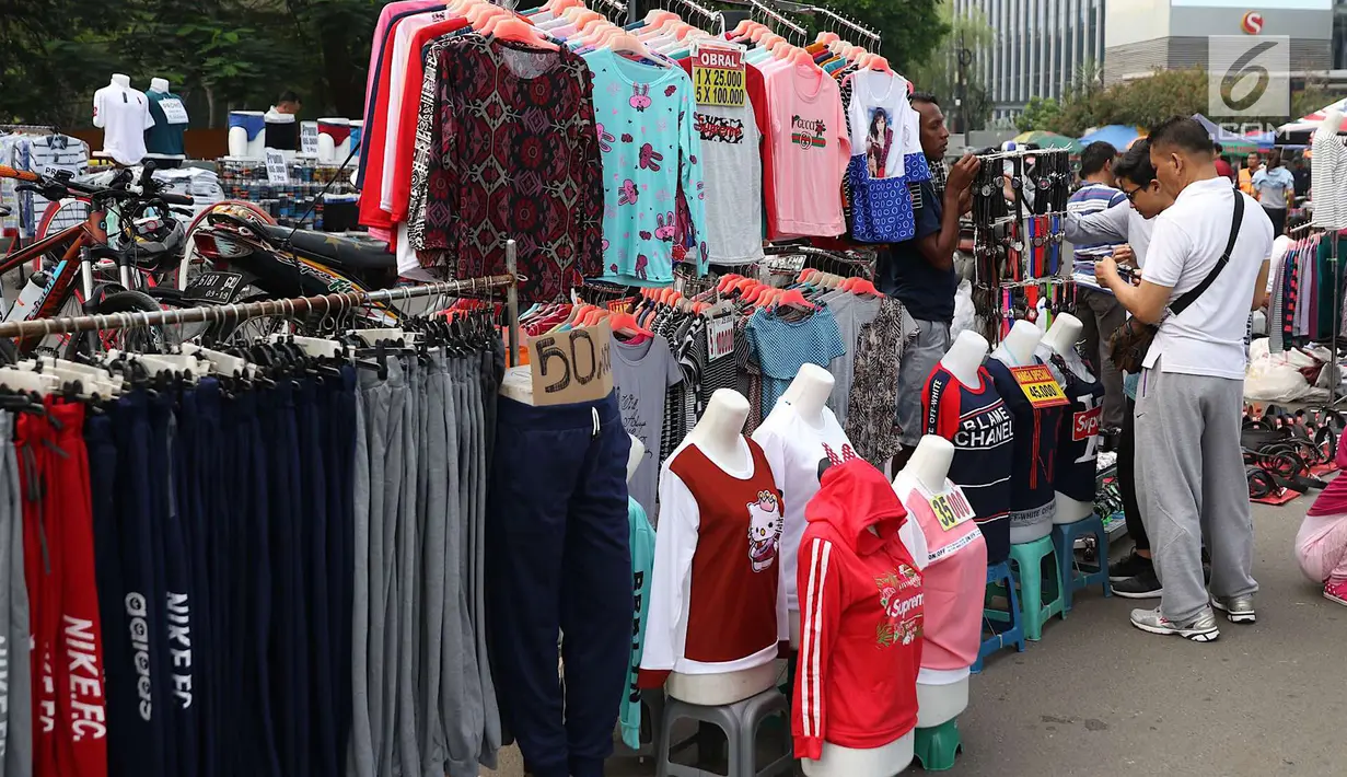 Pengunjung memilih barang saat pelaksanaan car free day di sepanjang Jalan Sudirman, Jakarta, Minggu (1/7). Kurangnya pengawasan menyebabkan banyak PKL yang berjualan tidak pada tempatnya dan memenuhi area CFD. (Liputan6.com/Immanuel Antonius)