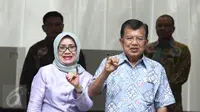 Wakil Presiden Jusuf Kalla (JK) didampingi istri, Mufidah Kalla, melakukan pencoblosan di TPS 03, Pulo, Kebayoran Baru, Jakarta Selatan  (Liputan6.com/Herman Zakharia)