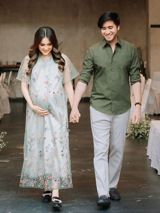 Vicy Melanie mengenakan lace dress floral di acara gender reveal anak perempuannya. Untuk sepatunya, Vicy memilih untuk mengenakan sepatu docmart warna hitam. Penampilan Vicy sangat simpel, namun tetap anggun dan memesona. Sementara Kevin Aprilio pakai kemeja warna hijau lumut dan dipadukan dengan celana warna ivory. Kevin juga pakai sepatu hitam sama dengan Vicy. (Liputan6.com/IG/@vicymelanie)