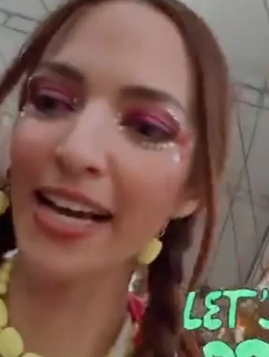 Gayanya semakin totalitas dengan mengaplikasikan makeup festival terlihat dari riasan matanya. Nia mengenakan eyeshadow pink shimmer dengan beads di sisi matanya dan lipstik glossynya. [@ramadhaniabakrie]