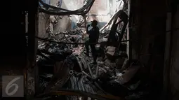 Seorang satpam mengecek keadaan kios usai terbakar di Pasar Senen, Jakarta, Jumat (20/1). Akibat kebakaran tersebut‎, total kerugian yang alami pedagang diperkirakan mencapai Rp 101,2 miliar. (Liputan6.com/Gempur M Surya)