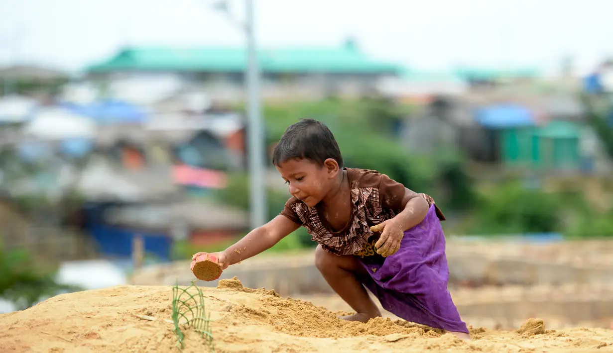 Seorang anak pengungsi Rohingya bermain pasir di Kamp Pengungsian Kutupalong, Ukhia, Bangladesh, Jumat (13/9/2019). Kamp ini adalah salah satu dari dua kamp pengungsian yang dikelola pemerintah di Cox's Bazar. (MUNIR UZ ZAMAN/AFP)