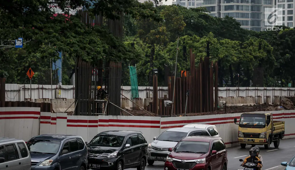 Kendaraan melintas disamping pembangunan proyek kereta ringan LRT di Jalan HR Rasuna Said, Kuningan, Jakarta, Rabu (20/12). Proyek yang saat ini dalam proses pemasangan tiang tersebut ditargetkan selesai Desember 2018. (Liputan6.com/Faizal Fanani)
