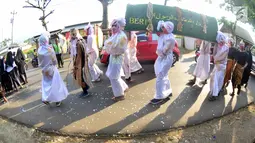 Sejumlah santri mengenakan kostum dan membawa keranda saat mengikuti pawai Hari Santri Nasional 2017 di Gunungpati, Semarang (22/10). Pawai ini dimeriahkan dengan pesta budaya nusantara, barongsai, drum band. (Liputan6.com/Gholib)