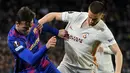 Gelandang Barcelona, Nico Gonzalez (kiri) berebut bola dengan gelandang Galatasaray, Berkan Kutlu selama pertandingan leg pertama babak 16 besar Liga Europa di stadion Camp Nou di Barcelona (11/3/2022). Barcelona bermain imbang atas Galatasaray 0-0. (AFP/Lluis Gene)