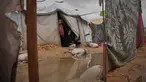 Nanaa Abu Jari memasak di luar tendanya setelah tenda tersebut terendam air hujan di Nuseirat, Jalur Gaza tengah, Jumat, 2 Januari 2026. Hingga awal Januari 2026, wilayah Gaza masih dihantam cuaca ekstrem yang memperparah krisis kemanusiaan di sana. (AP Photo/Abdel Kareem Hana)