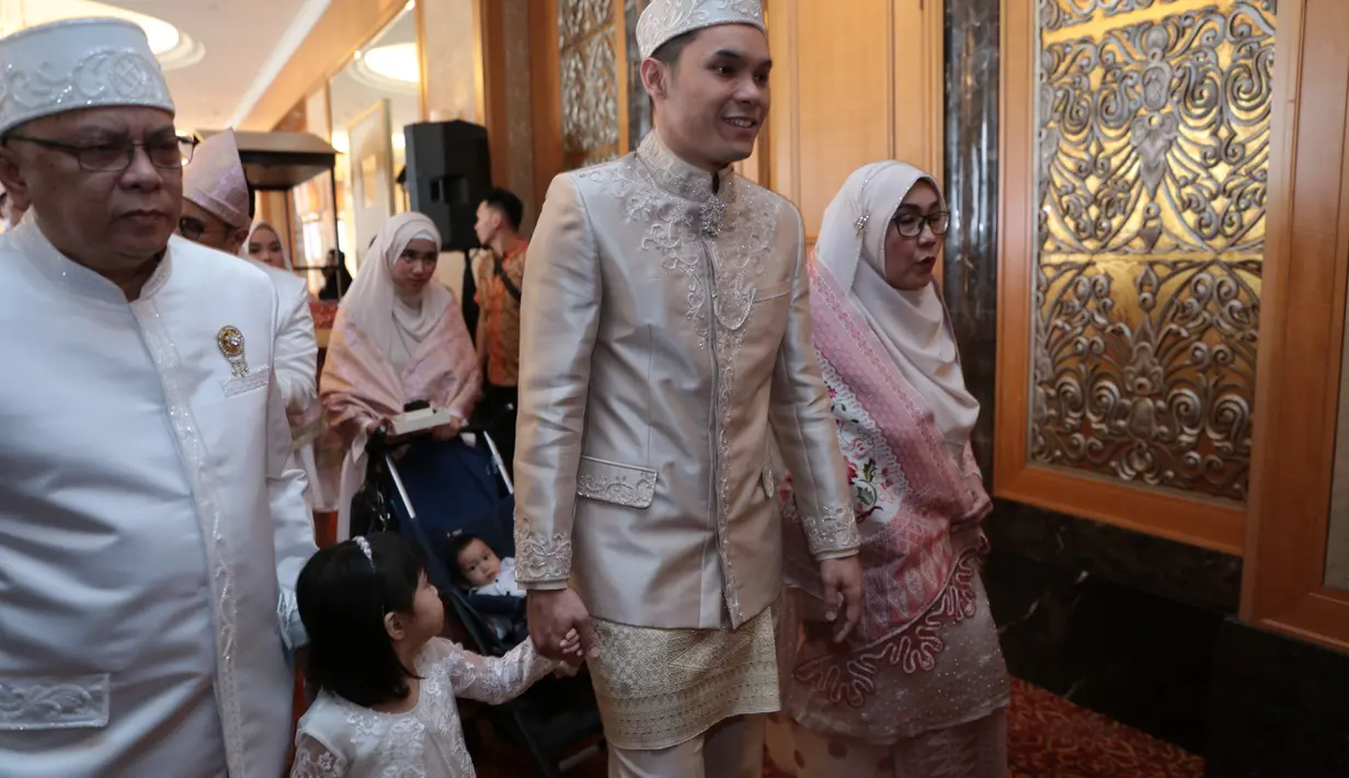 Berbalut beskap putih gading, VJ Ben diapit orangtua dan keluarga. Lantunan Salawat Badar terus mengiringi langkah Ben menuju tempat akad nikah yang disediakan. (Adrian Putra/Bintang.com)