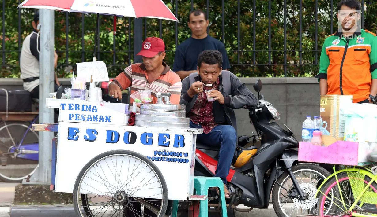 Seorang pedagang es doger menjajakan dagangannya di sisi jalan sekitar kawasan Patung Kuda Jakarta, Rabu (5/1/2019). Mereka mencoba peruntungan saat para buruh melakukan aksi perayaan Hari Buruh International atau May Day. (Liputan6.com/Helmi Fithriansyah)