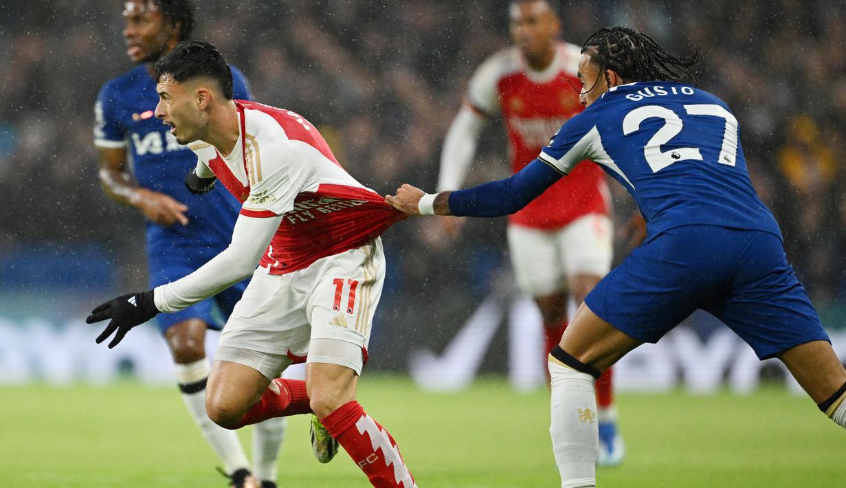 Pemain Arsenal, Gabriel Martinelli, berusaha melepaskan diri dari penjagaan pemain Chelsea, Malo Gusto, pada lanjutan Liga Inggris, Sabtu (21/10/2023). (AFP/Justin Tallis)