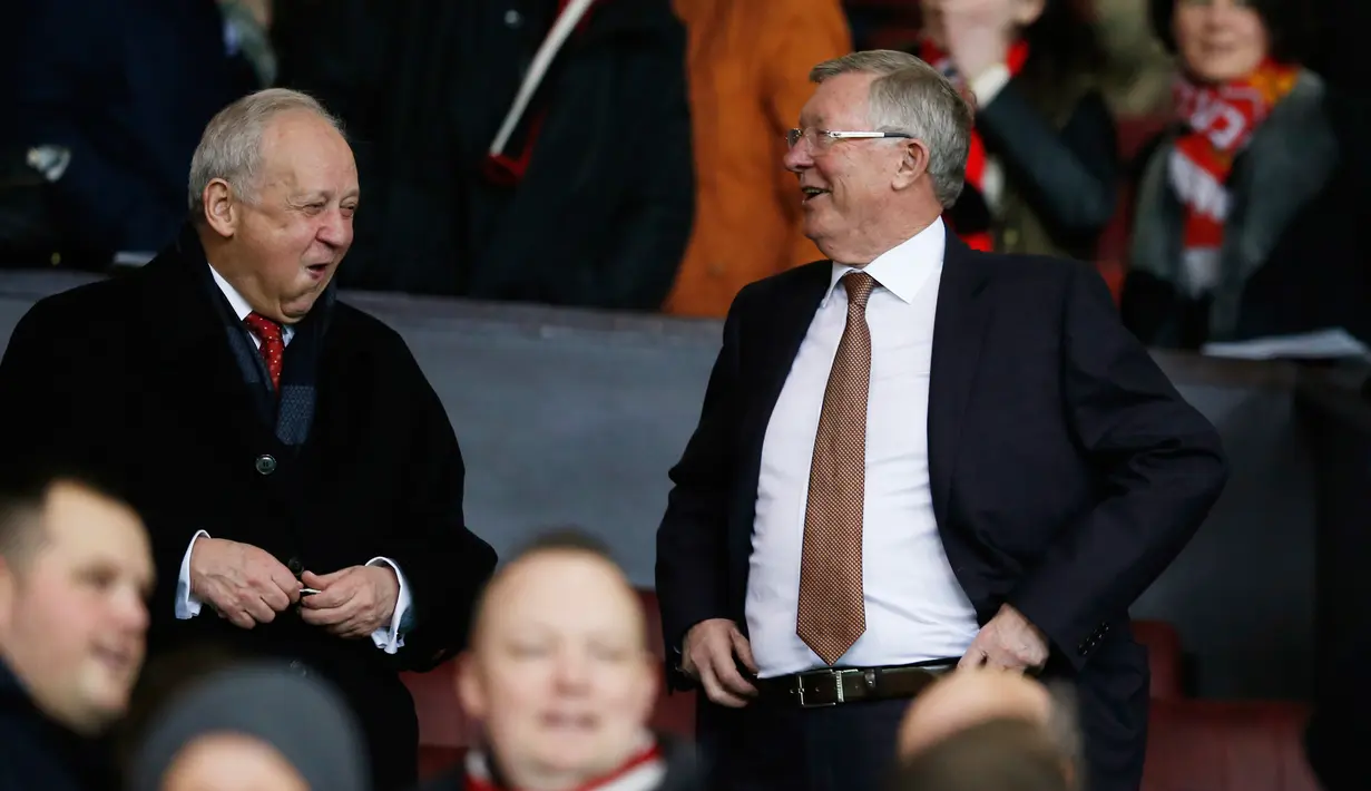 Sir Alex Ferguson berbincang dengan rekannya saat menyaksikan pertandingan antara Manchester United dengan Chelsea di Stadion Old Trafford, Inggris (28/12). MU bermain imbang dengan Chelsea dengan skor 0-0. (Reuters/Phil Noble)