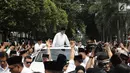 Bakal Calon Presiden, Prabowo Subianto berdiri di atas mobilnya dalam perjalanan menuju Gedung KPU RI, Jakarta, Jumat (10/8). Ketua Umum Gerindra Prabowo Subianto berangkat ke KPU untuk mendaftarkan diri sebagai capres. (Liputan6.com/Herman Zakharia)