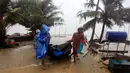 Warga membawa barang miliknya sebelum Badai Tropis Pabuk mendekat di Pak Phanang, di Nakhon Si Thammarat, Thailand (4/1). Hujan, angin dan gelombang air laut akan melanda Thailand selatan akibat badai tropis Pabuk. (AP Photo/Sumeth Panpetch)
