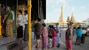 Ini merupakan pemilu pertama yang digelar dalam lima tahun terakhir sejak kudeta militer tahun 2021 yang memicu perang saudara berkepanjangan. Tampak dalam foto, para pemilih mengantre untuk memberikan suara mereka di tempat pemungutan suara, berlatar belakang Pagoda Sule, di Yangon, Myanmar, Minggu, 28 Desember 2025, (AP Photo/Thein Zaw)