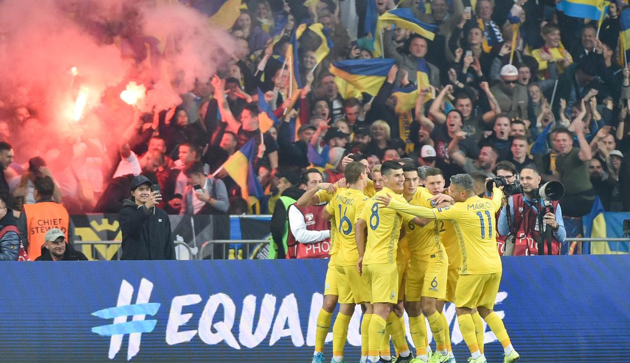 Para pemain Ukraina merayakan gol yang dicetak Andriy Yarmolenko ke gawang Portugal pada laga Kualifikasi Piala Eropa 2020 di Stadion NSK Olimpiyskyi, Kiev, Senin (14/10). Ukraina menang 2-1 atas Portugal. (AFP/Genya Savilov)